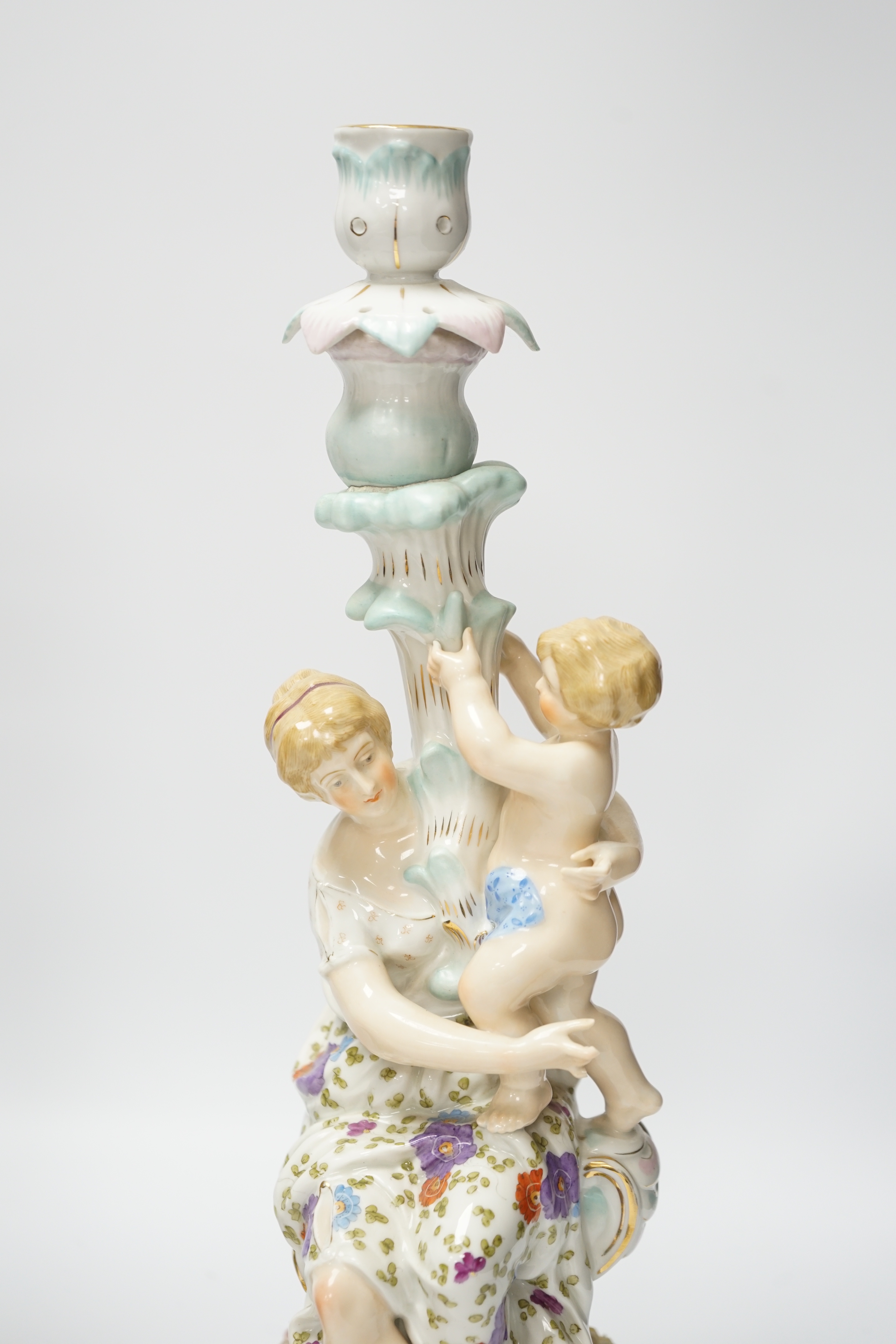 A pair of German floral encrusted porcelain candlesticks of a mother and child group, 38cm high